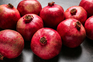 Fototapeta na wymiar Whole pomegranates on gray background