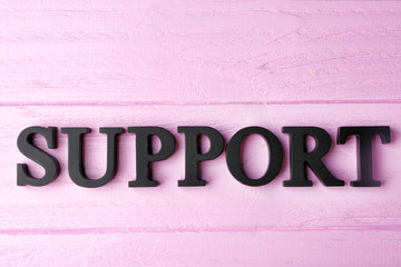 Word SUPPORT on color wooden background