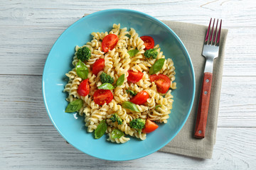 Pasta salad with tomatoes and broccoli on wooden table