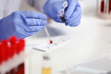 Woman working with blood sample in laboratory, closeup