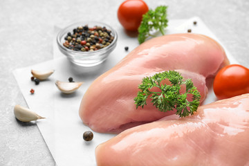 Raw chicken meat with spices on parchment