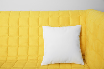 Blank soft pillow on cozy couch