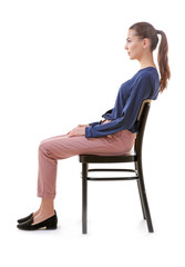 Incorrect posture concept. Young woman sitting on chair against white background