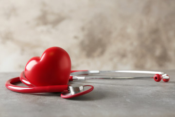 Stethoscope and red heart on table