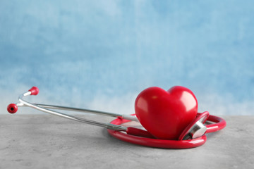 Stethoscope and red heart on table