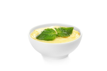 Creamy cheese and basil leaves in bowl, isolated on white