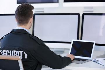 Handsome security guard in surveillance room