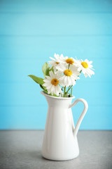 Vase with bouquet of beautiful flowers on color background