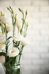 Glass vase with bouquet of beautiful flowers on color background