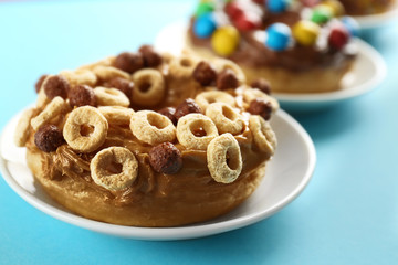 Plate with delicious donut on color background, closeup