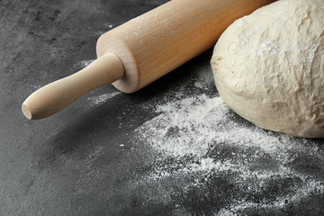 Rolling pin with dough on kitchen table