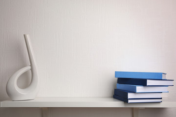 Stack of books on white wooden shelf