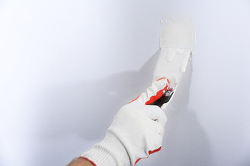 Hand of worker making repair in room