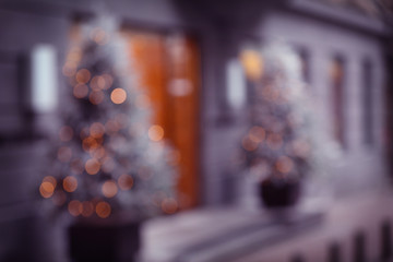 Blurred background of Christmas garlands on trees near shop entrance