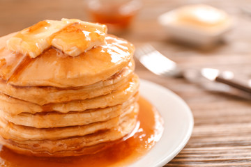 Delicious pancakes with butter and maple syrup, closeup