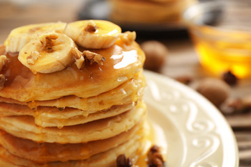 Tasty pancakes with banana, nuts and honey, closeup