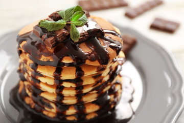 Delicious pancakes with chocolate syrup and mint, closeup