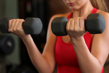 Sporty young woman work out biceps.