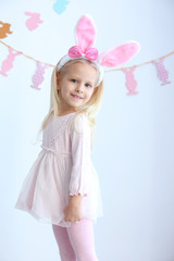 Cute little girl with bunny ears at home
