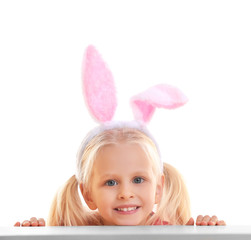 Cute little girl with bunny ears and basket full of Easter eggs on white background