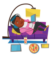 Woman lying on sofa with many gadgets.