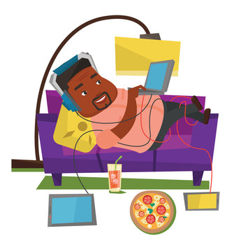 Man lying on sofa with many gadgets.