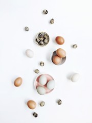White and brown Easter eggs and quail eggs on white background. Flat lay, top view. Traditional spring concept.