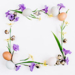 Naklejka na ściany i meble Frame wreath made of Easter eggs, quail eggs, yellow and purple flowers on white background. Flat lay, top view. Traditional spring concept. Easter concept.