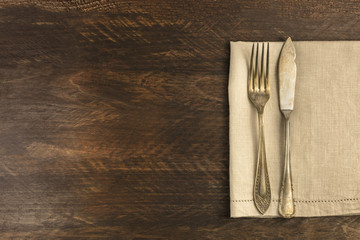 Vintage fork and knife on wooden background