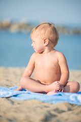 Baby playing with toys on the sandy beach near the sea. Cute little kid in  sand on tropical beach. Ocean coast.