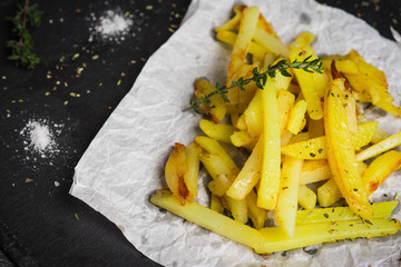Fried potatoes with spices on the dark background