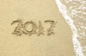 Happy New Year 2017 sand beach by the sea.