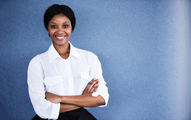 Young black female business executive smiling at camera with her arms crossed while smiling at the...