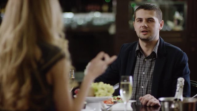 calm man in restaurant arguing with woman