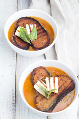 Dish with soup, cheese and bread on a white background
