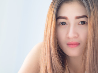 Fototapeta premium Portrait of Asian woman in white vest, expressing the idea of broken heart and sadness. hopeless and await, concept.