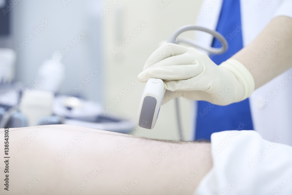 Wall mural doctor conducting ultrasound examination of abdomen to a patient