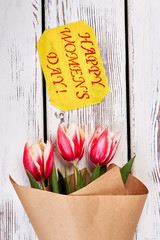 Tulips on wooden background. Wishing you lots of love.