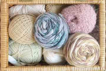 Fototapeta na wymiar A handicraft weave basket full with colorful yarns, top view.