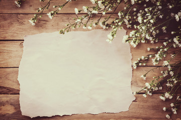 White flower on grunge wood board and paper background with space.