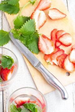 refreshing drink with strawberries and mint on a light background