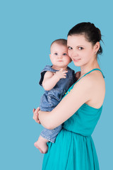 happy mother holding her baby, isolated on blue