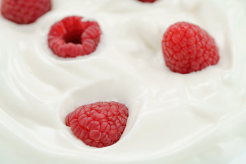 macro photo of organic yogurt with fresh raspberries, food background