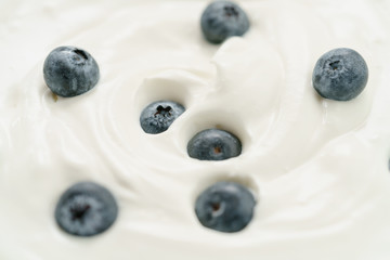 macro photo of organic yogurt with fresh blueberries, food background