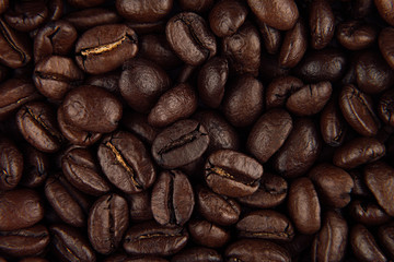 Roasted coffee beans closeup top view as background.