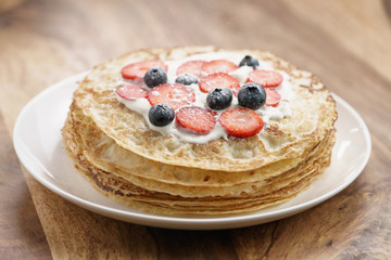 fresh blinis or crepes with fresh berries and cream, sweet food