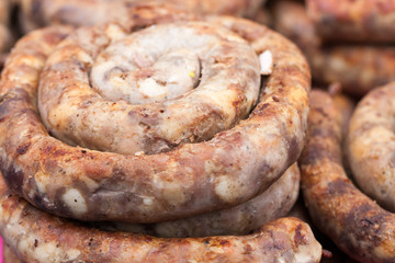 Roasted spiral pork sausages as a background. Selective focus