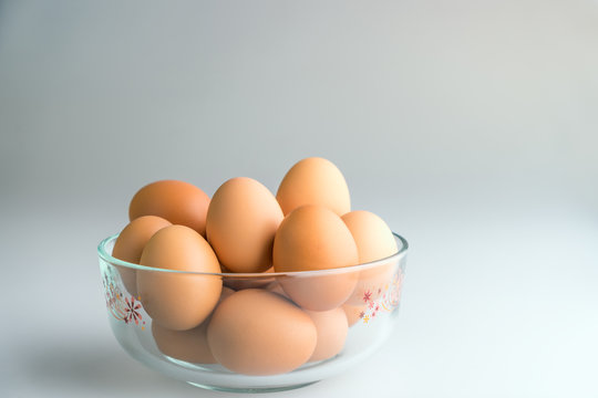 Fresh eggs in a bowl on a white background.