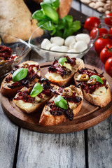 Appetizer bruschetta with sun-dried tomatoes, olives and mozarel