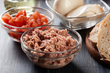 Ingredients ready for preparing bruschetta with tuna, mozzarella cheese and tomatoes